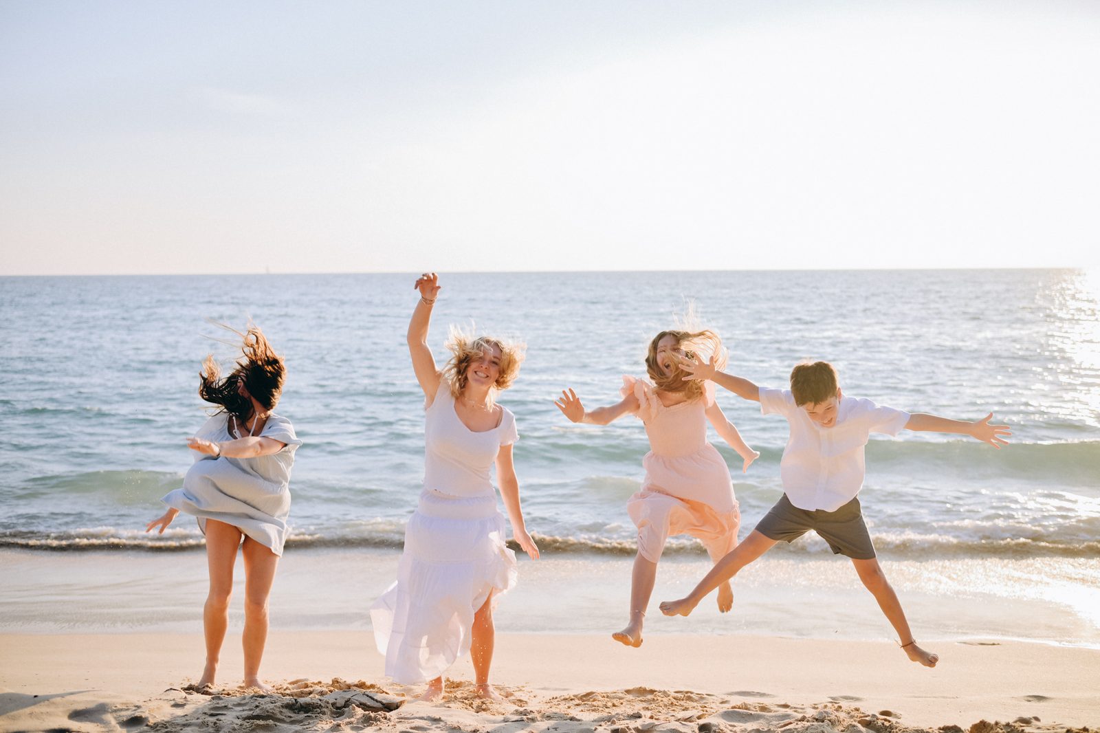 Family jumping and laughing on the beach