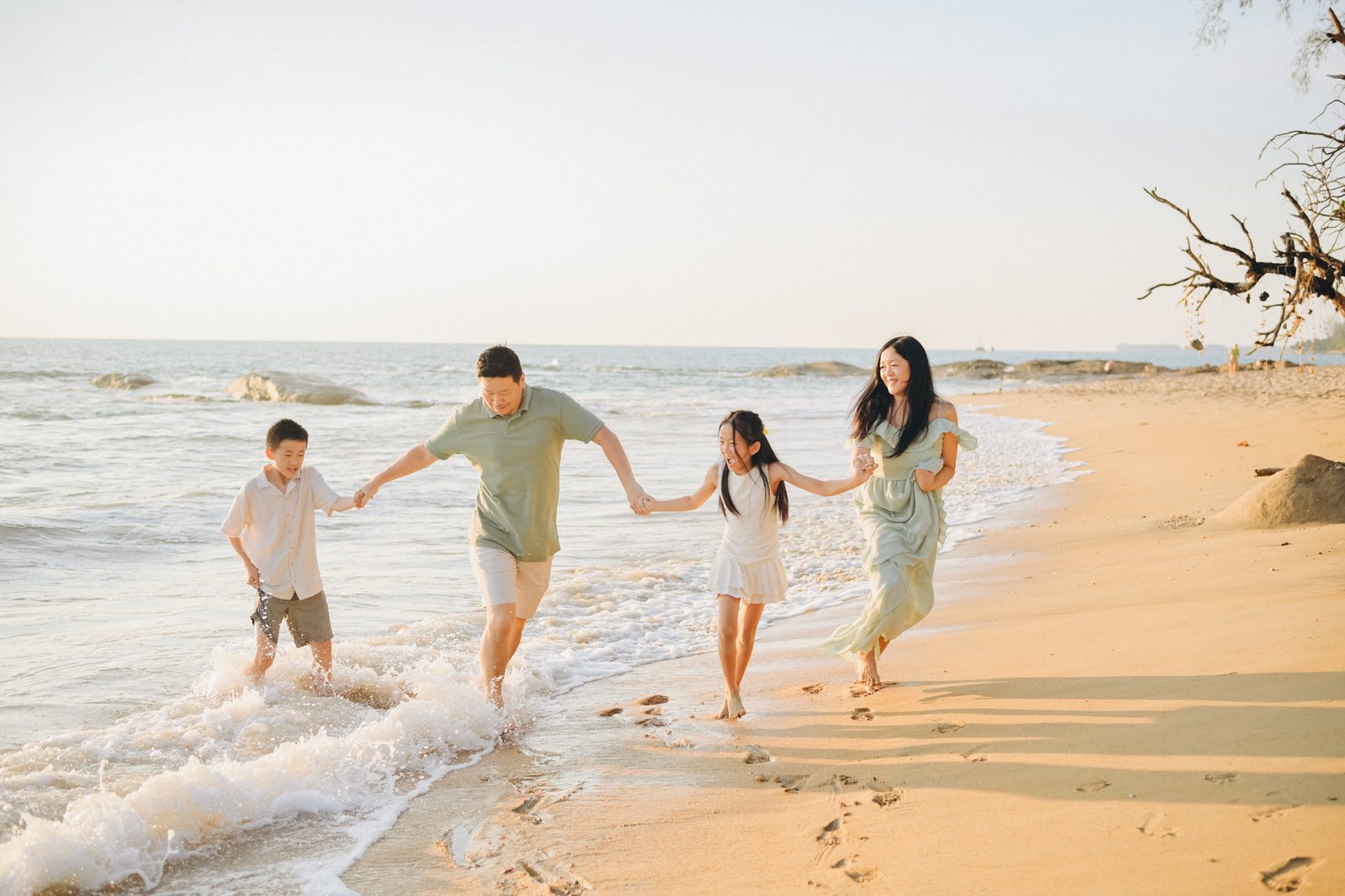 Family running along the shore in Khao Lak