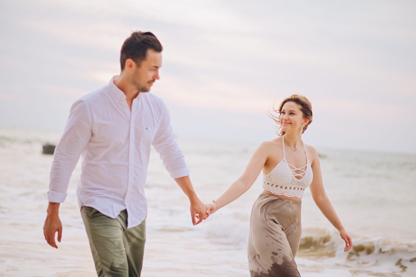 Honeymoon couple walking hand in hand at sunset in Khao Lak