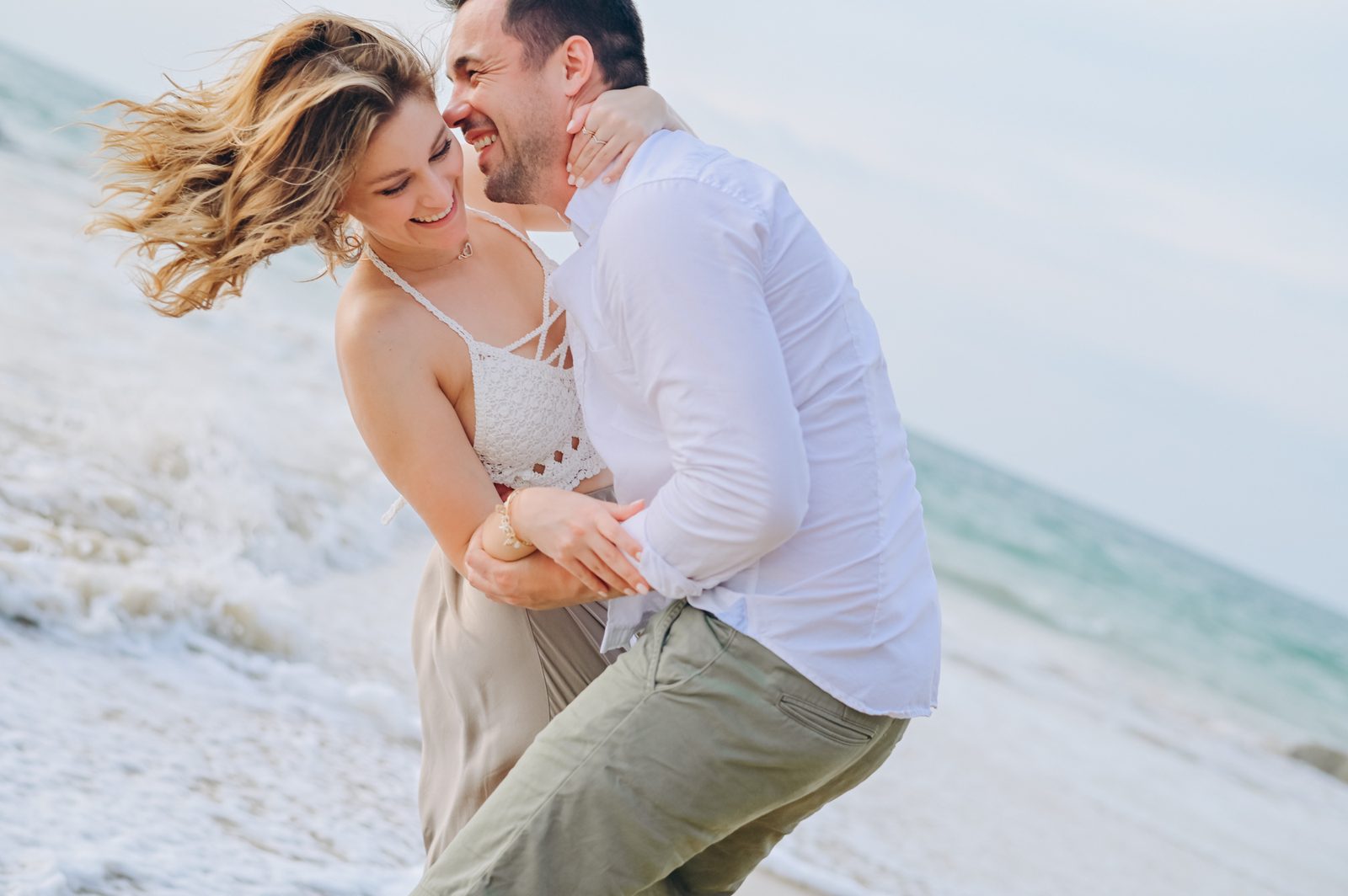Honeymoon couple playing in the waves in Khao Lak