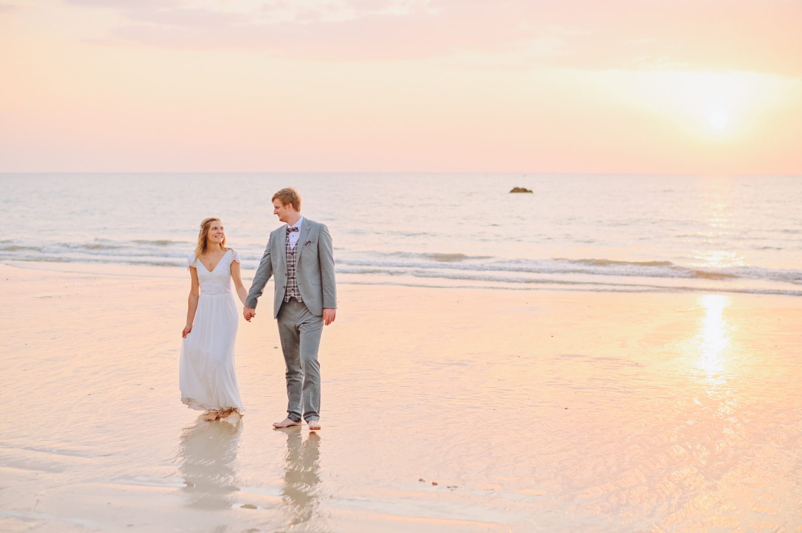 Wedding couple walking on the beach at sunset in Khao Lak
